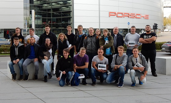 EBERLE Auszubildende stehen vor dem Porsche Werk für ein Gruppenfoto in Position 